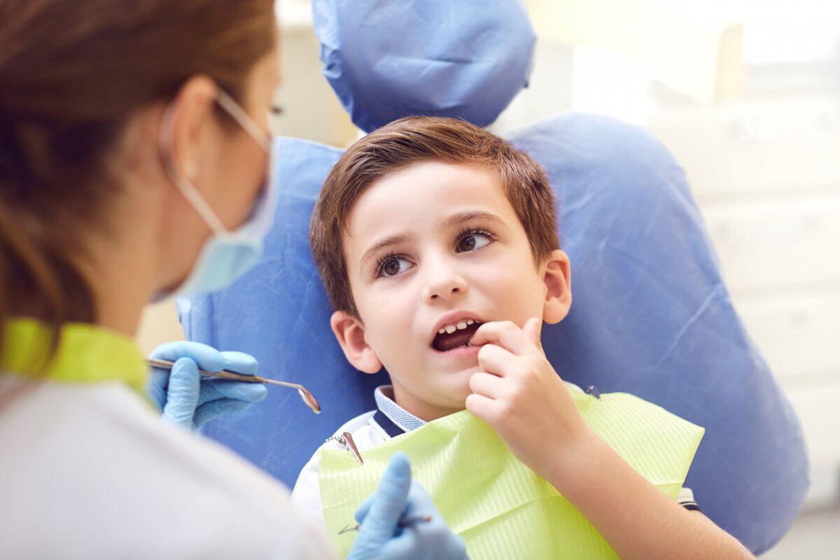 Child At The Dentist Pointing To His Cavity