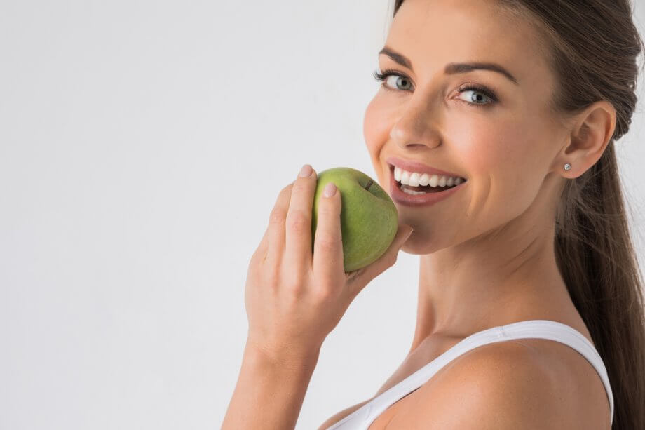 Woman biting green apple